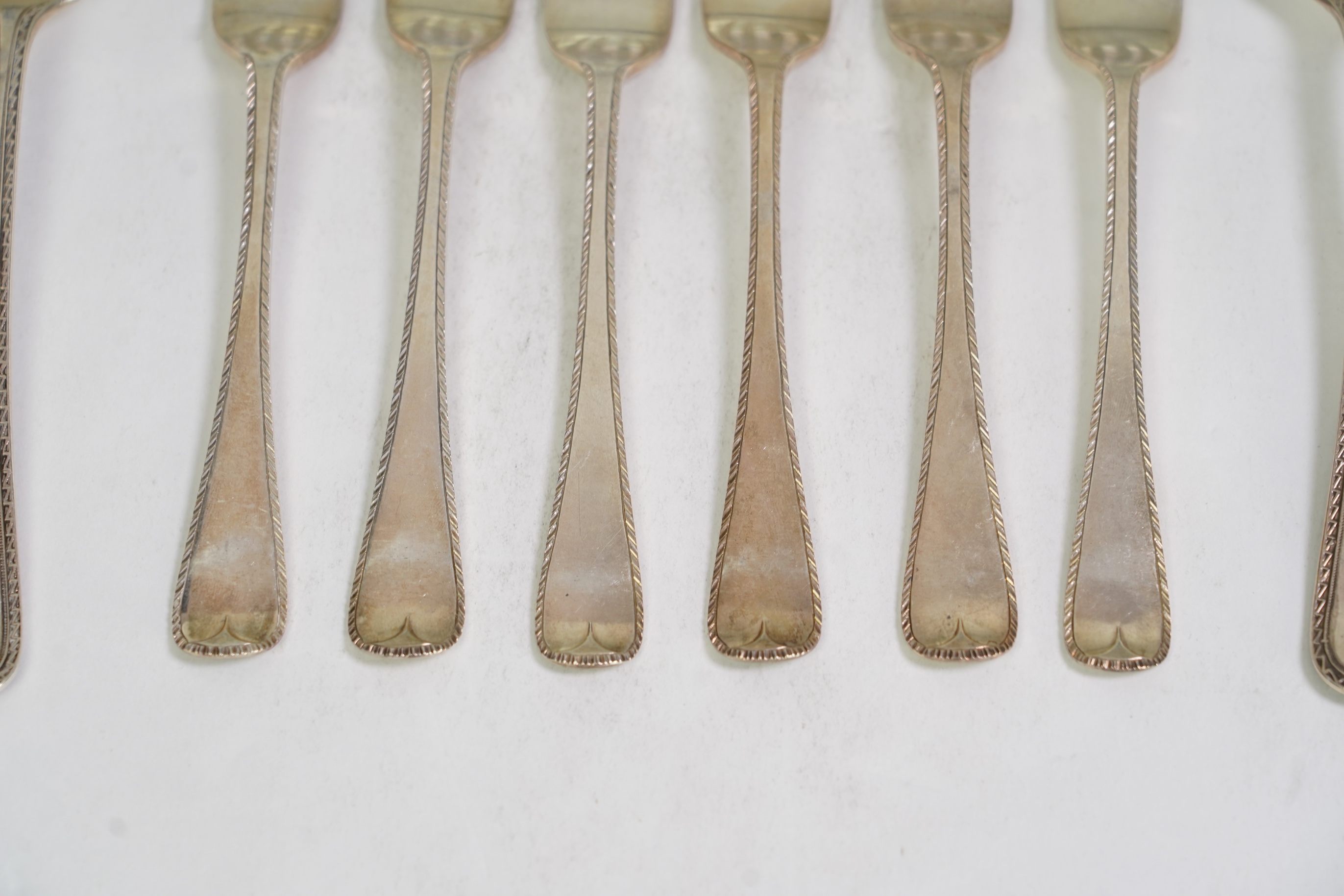 A set of six George V fancy Old English pattern table spoons by Elkington & Co, Birmingham, 1919, 22.2cm, together with a set of six fancy Hanoverian pattern table forks, Goldsmiths & Silversmiths Co Ltd, London, 1918, 3